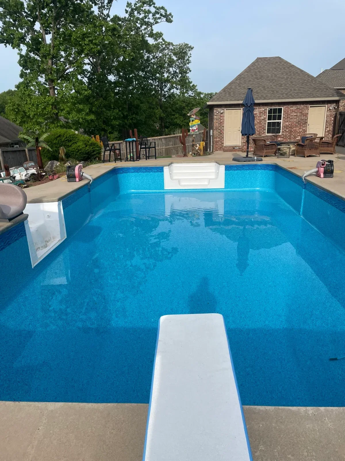 In-ground pool with bright blue plaster finish and white coping installed along edges