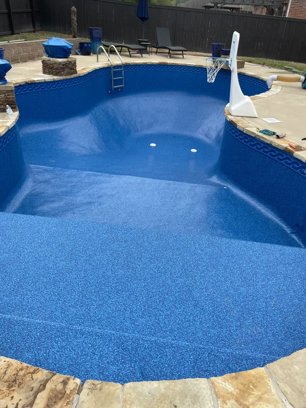 In-ground pool with new blue textured vinyl liner, return jets, and skimmer installation