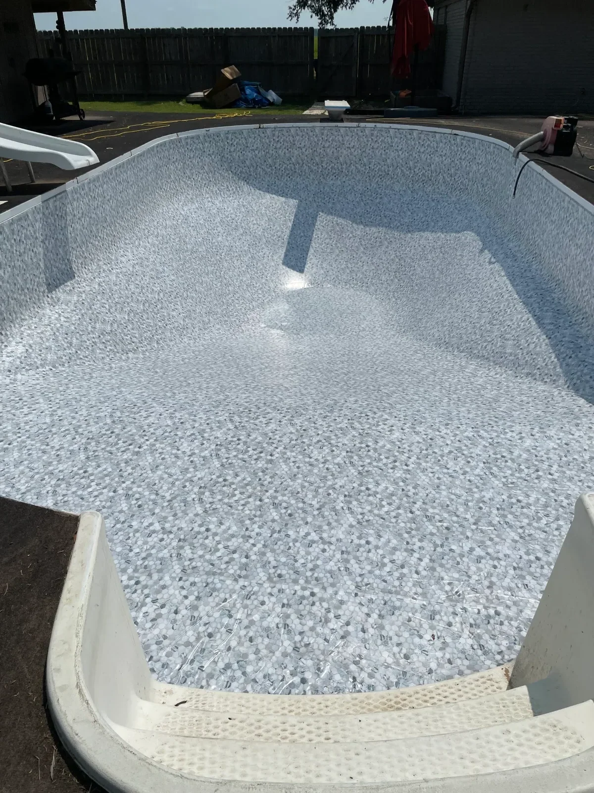 White aggregate pool interior resurfacing with uniform finish texture