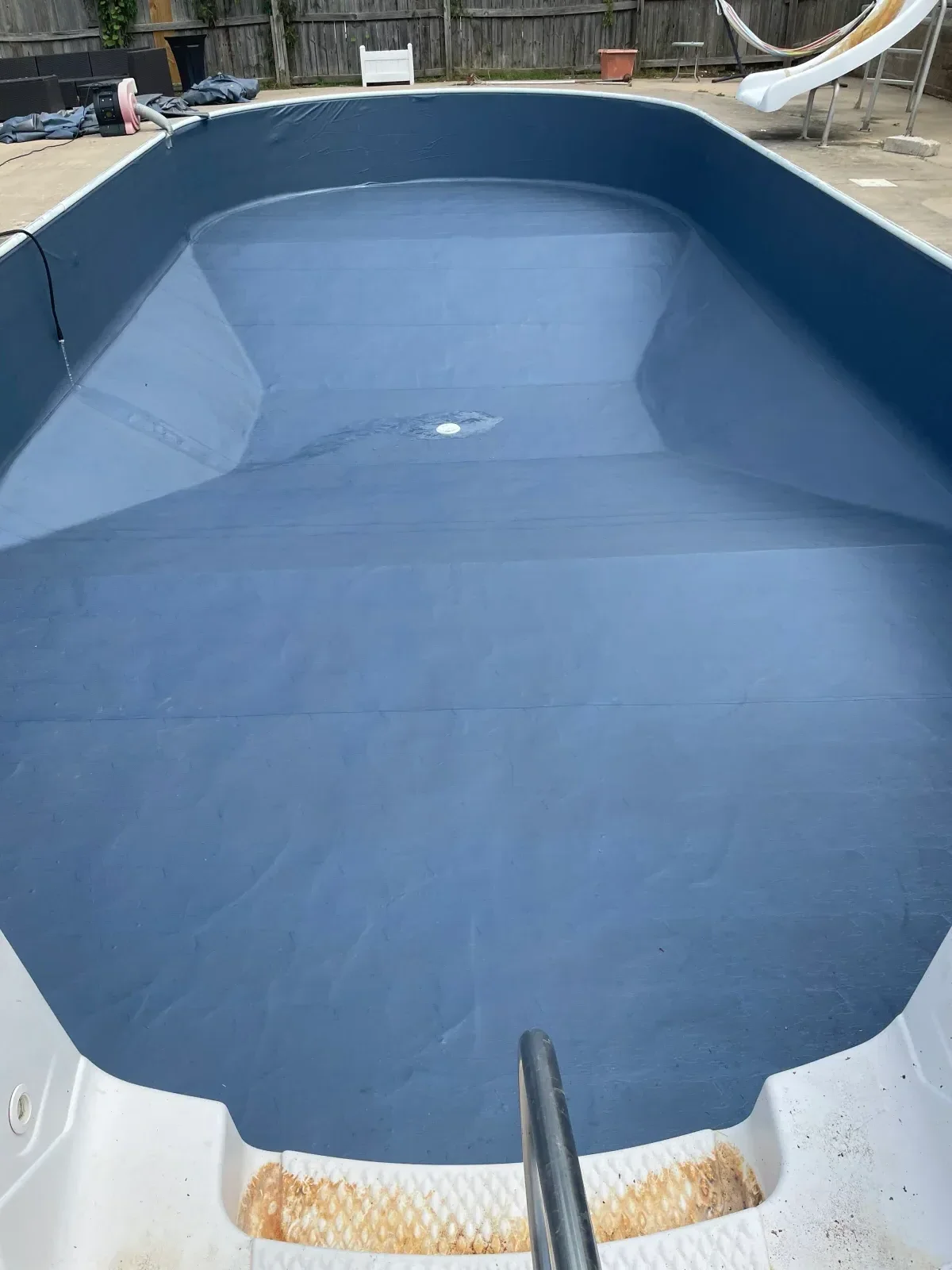 In-ground pool with newly resurfaced blue interior coating and clean finish